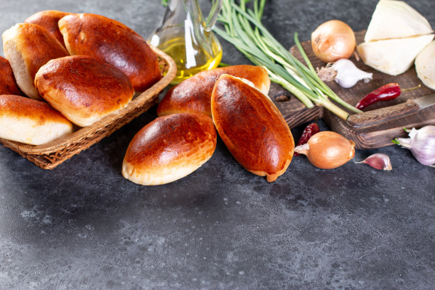 新鲜烤制的鸡蛋和葱馅肉饼。深棕色的表。传统的俄罗斯和乌克兰自制美味的pirozhki。图片下载