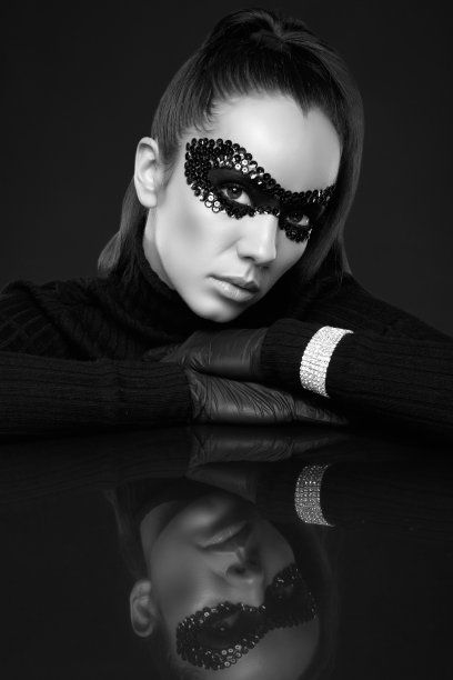 优雅的黑发女人在亮片面具摆姿势在镜面上图片下载