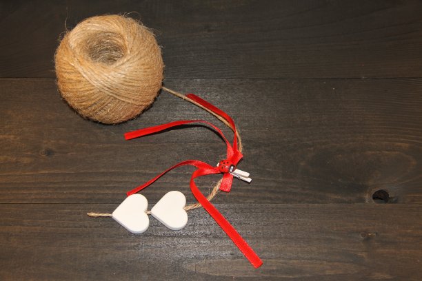 一团毛线，一根红丝带和一颗白色的心图片下载