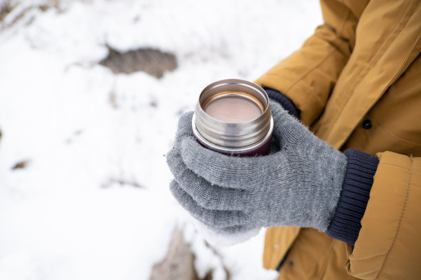 不认识的人拿着装有热巧克力的小热水瓶图片下载