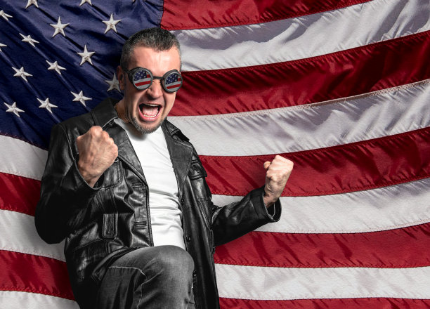 一名男子在美国国旗上庆祝胜利。带有美国国旗反光的眼镜。图片下载