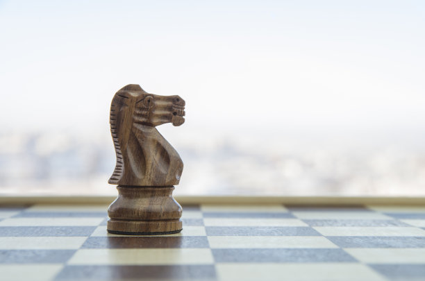 骑士棋子。背面有棋子的棋盘。商务谈判作为背景业务概念和战略概念与拷贝空间。图片下载