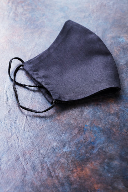 手工制作的黑色防护面具，背景为黑色。防病毒可重用口罩。本空间图片下载