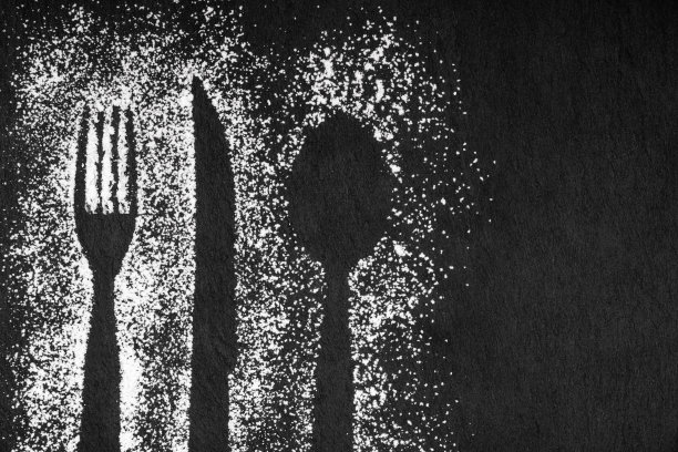 黑色石板背景与勺和叉印面粉和刀，概念形象。本空间图片下载