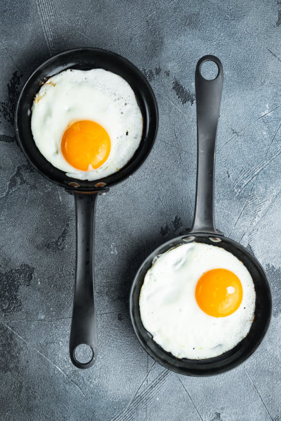 煎蛋樱桃番茄和面包的早餐，在铸铁煎锅，灰色的背景，俯视图平lay图片下载