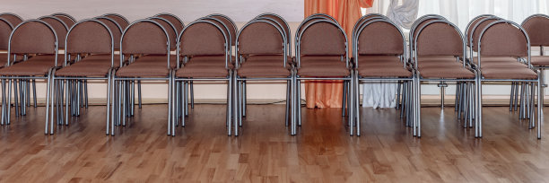 在讲堂里，镶木地板上一排排的棕色现代椅子。图片下载