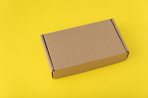 黄色背景的纸板箱。包装的包裹。副本的空间。模拟了图片下载