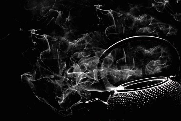 黑色背景上的质朴茶壶。热气腾腾的茶水壶。烹饪概念。图片下载