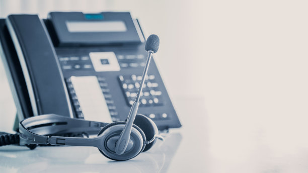沟通支持，呼叫中心和客户服务帮助台。电话键盘上的VOIP耳机。图片下载