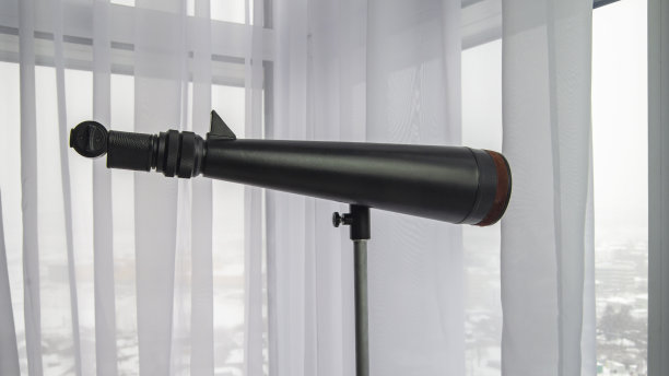 顶层窗户边的望远镜图片下载