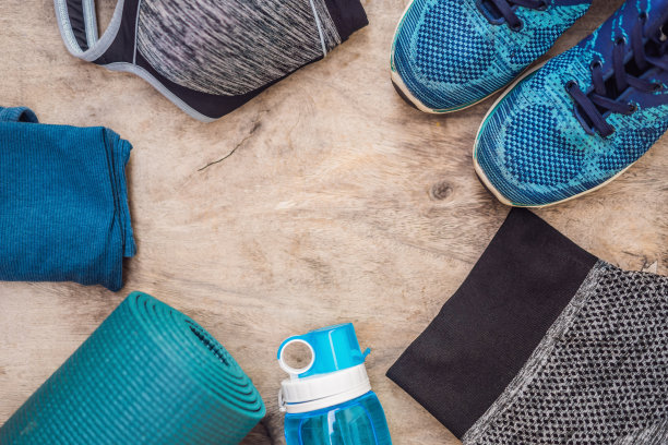 一切运动绿松石，蓝色阴影在木背景。瑜伽垫，运动鞋，运动服和一瓶水。健康生活方式、运动和饮食的概念。运动设备。本空间图片下载