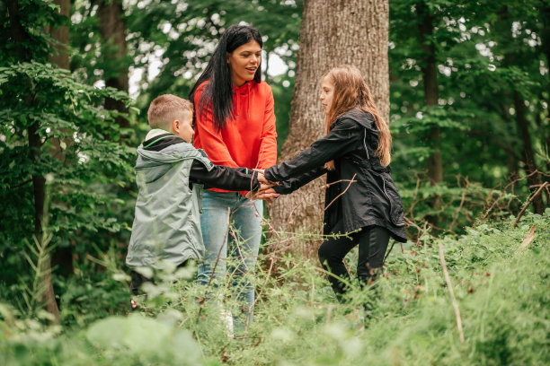 妈妈和她的孩子在森林里双手合十图片下载