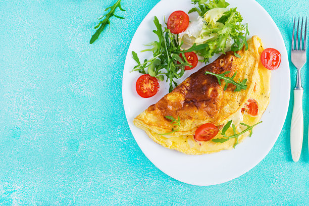 早餐。煎蛋卷配番茄、芝士和芝麻菜。意式煎蛋饼。生酮、酮类的食物。俯视图，平放图片下载