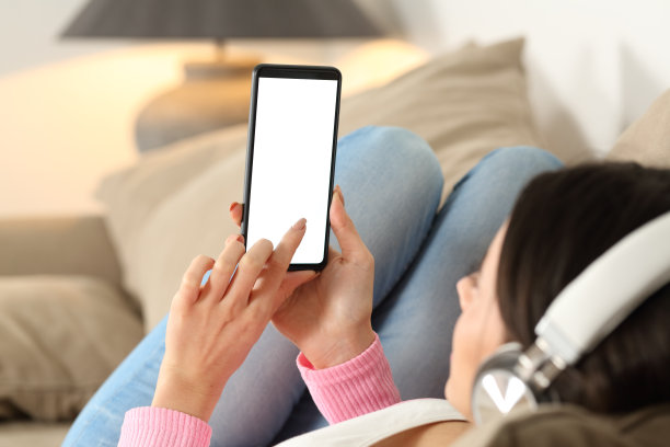 戴着耳机看手机空白屏幕的女人图片下载