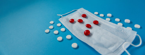 医用口罩和药片，蓝色背景图片下载