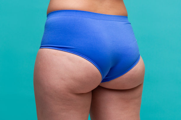 肥胖的臀部和臀部，肥胖的女性身体在蓝色的背景图片下载