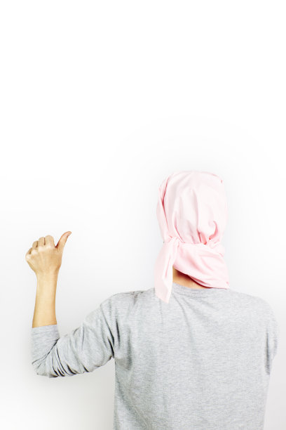 一位戴着粉色癌症头巾的女士举起了大拇指。图片下载