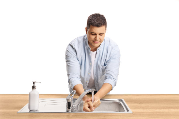 一个漫不经心的年轻人在水槽里洗手图片下载