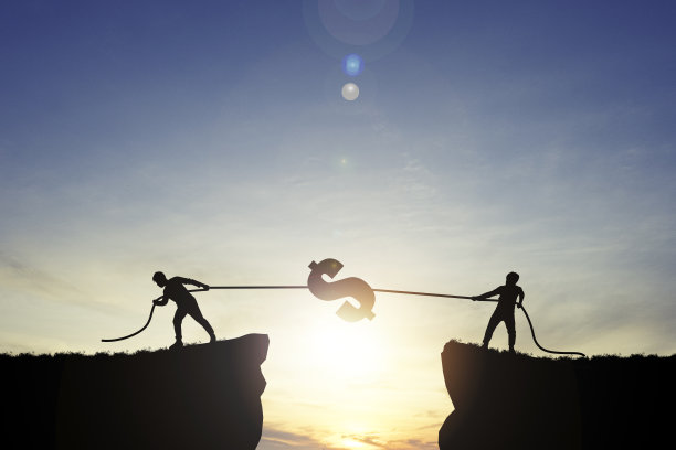 日出蓝天上，两名男子拉着美元标志的剪影，美元是世界上主要的货币兑换。图片下载