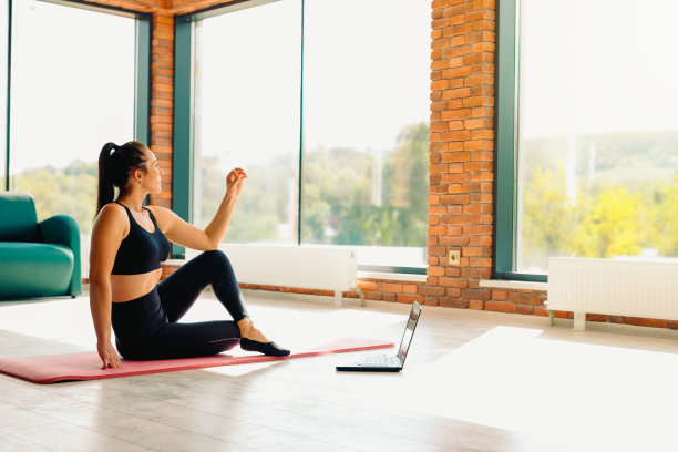 瑜伽教练。一个运动女性与一个美丽的体形参与一个在线视频锻炼。冥想，一种健康的生活方式，一种新的正常观念。照片与空白的边空间图片下载