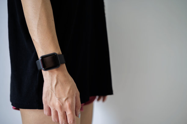 裁剪的女孩使用灰色墙壁上的空白屏幕智能手表的观点图片下载