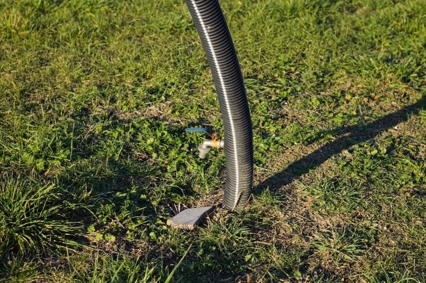 用一根塑料软管支撑的用来灌溉草坪的水龙头(意大利，佩萨罗)图片下载