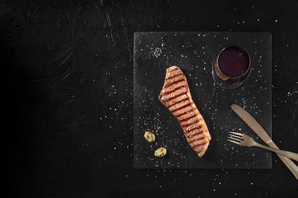 烤牛排与红酒，上方拍摄在一个黑暗的背景图片下载