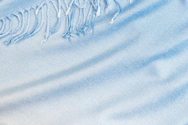 背景纺织品与针织围巾的纹理与流苏，蓝色织物的颜色梯度在柔和的阴影，衣服和配饰图片下载