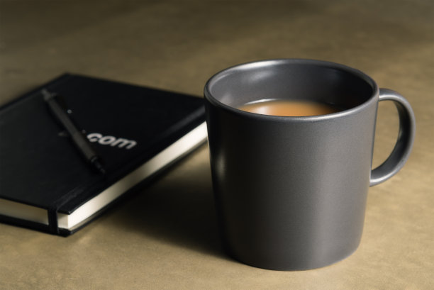 灰色的咖啡杯，里面有铅笔和书。图片下载