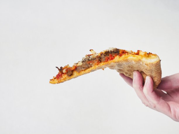白色背景下手持披萨的特写镜头图片下载