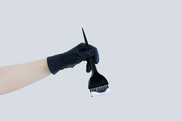 染发。黑色刷子与染发剂在白人妇女的手中。图片下载