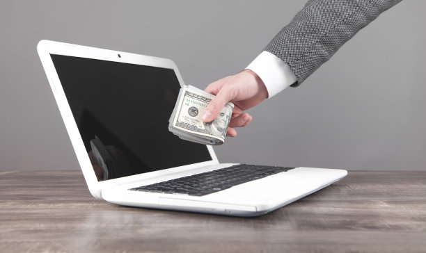一个拿着钱的人拿着笔记本电脑。在互联网上赚钱图片下载