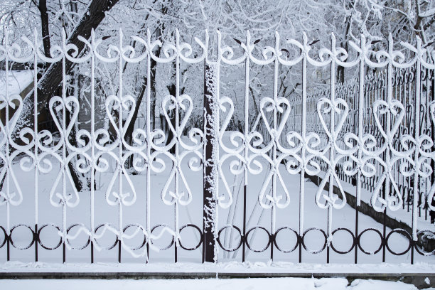 城市公园围栏在雪中，冬季景观在城市中。图片下载