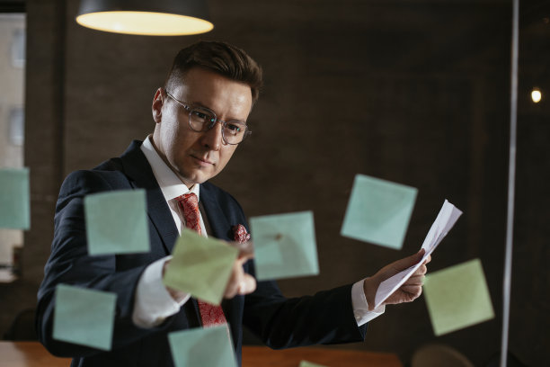 会议室的商人在玻璃墙上使用便利贴。图片下载