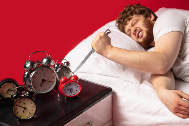 男人醒来，他对闹钟响很生气，用菜刀把它关掉图片下载