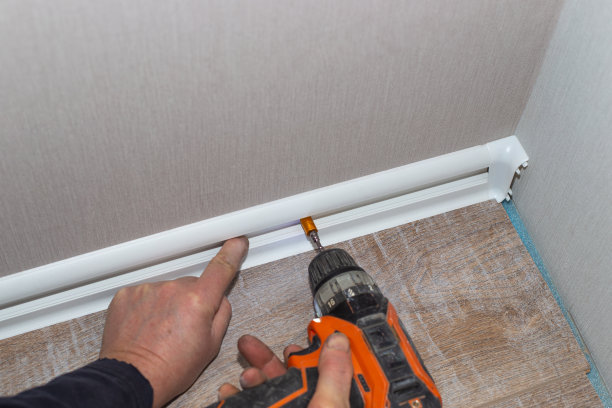 主用钻头将地板底座安装到墙上。家庭和办公室的装修和改善图片下载