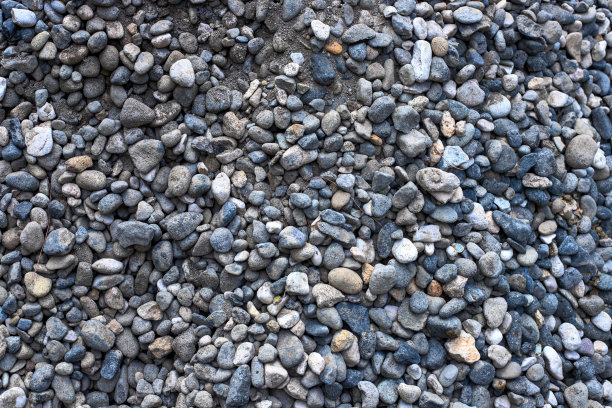灰色砾石堆特写照片。粗糙的灰色石材路面模板。破碎的石头纹理。道路建筑材料。建筑工地的概念图片下载