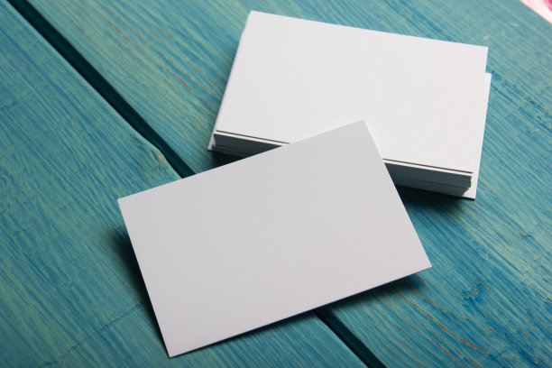 蓝色木质背景的空白名片。企业文具，品牌模型。创意设计师的办公桌。平的。文本复制空间图片下载
