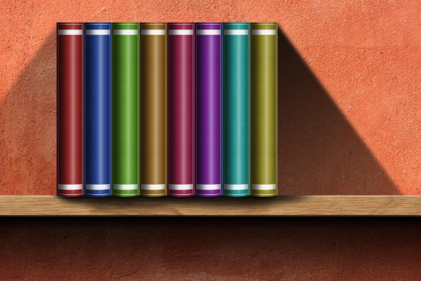 木制书架上的多色书籍，背景是橙色的墙壁图片下载