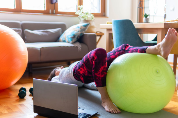 快乐活跃的老年妇女在家里用健身球做运动图片下载