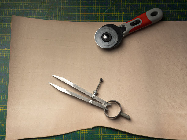 一个制革工人在一个绿色的自愈合的垫子上做一个电池的皮箱图片下载