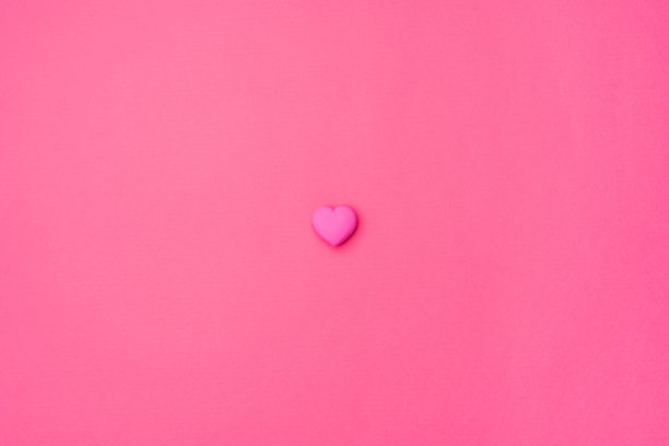 粉红色的心孤立在中心，在一个空的彩色粉红色背景。爱的象征为快乐的女人，母亲，情人节，生日问候浪漫的明信片图片下载