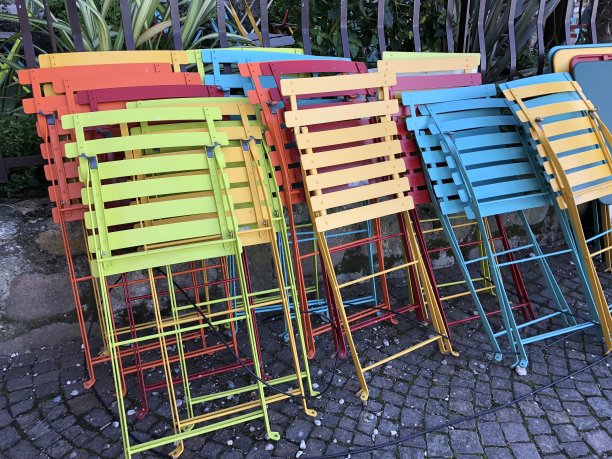 折叠椅，折叠椅，红蓝橙绿黄相间的折叠椅，在意大利的一家餐厅café户外图片下载