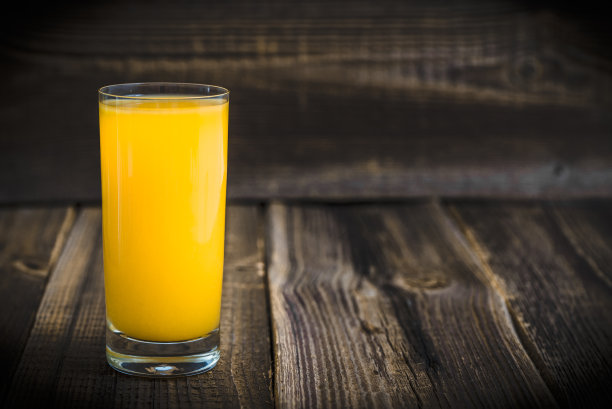 一杯橙汁和新鲜的橙子放在木头上图片下载