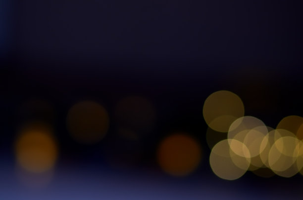 模糊的黄色圆形灯光在黑暗的背景上图片下载