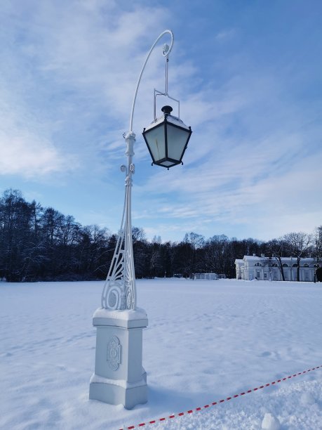 在圣彼得堡埃拉金岛的一个白雪覆盖的公园里，开放的美丽的路灯映衬着亭台楼阁和蓝天白云图片下载