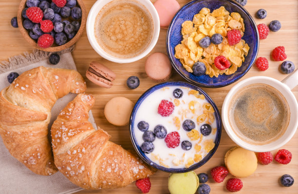 意大利浓咖啡加奶泡，羊角面包，浆果和牛奶什锦早餐。美味的健康的早餐。薄片和甜点。高质量的照片图片下载