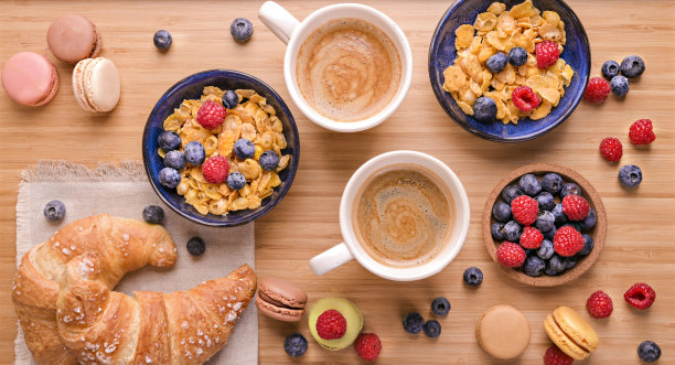 情人节的甜蜜惊喜。一对情侣的早餐。木桌上放着芳香的咖啡、莓果什锦麦片和甜糕点。以上。高质量的照片图片下载