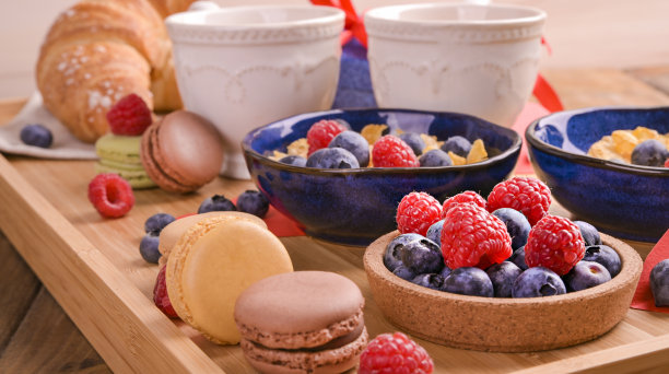 情人节为一对情侣准备的早餐。木桌上放着芳香的咖啡、莓果什锦麦片和甜糕点。垂直的照片。高质量的照片。图片下载