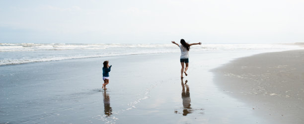 父母和孩子在海滩上跑步图片下载